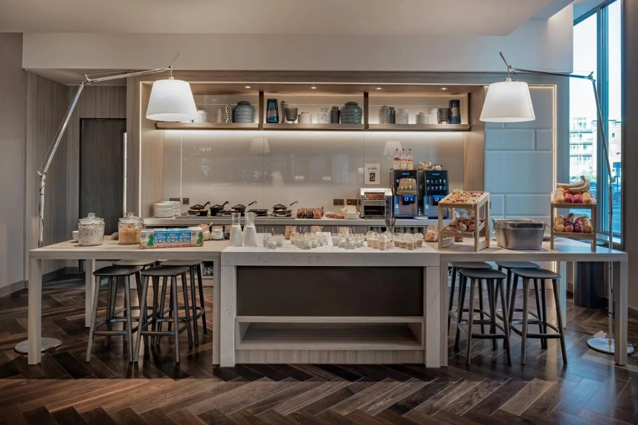 a kitchen with a large island with bar stools at AC Hotel by Marriott Manchester City Centre in Manchester