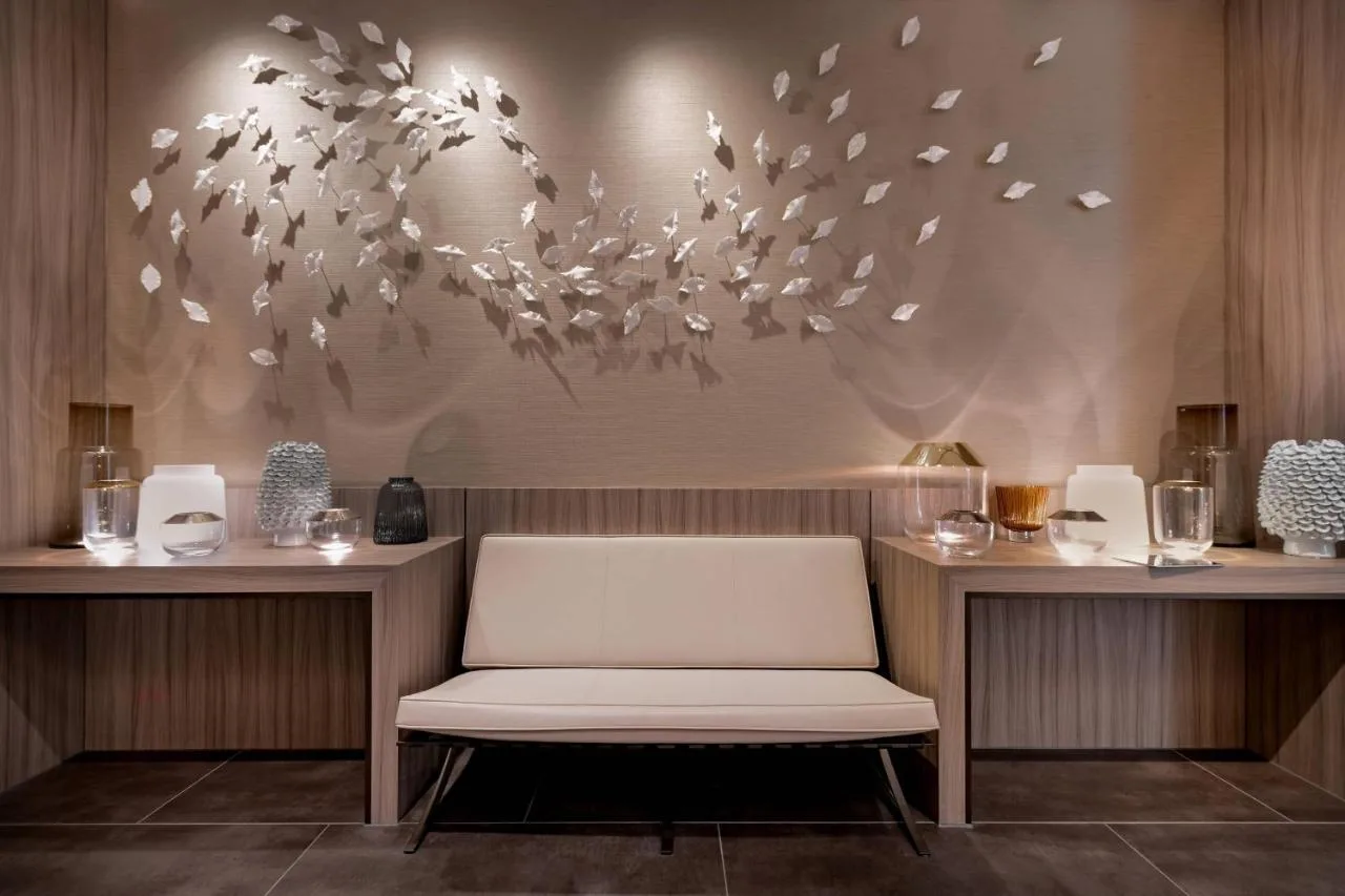 a white bench in a room with a chandelier at AC Hotel by Marriott Manchester City Centre in Manchester