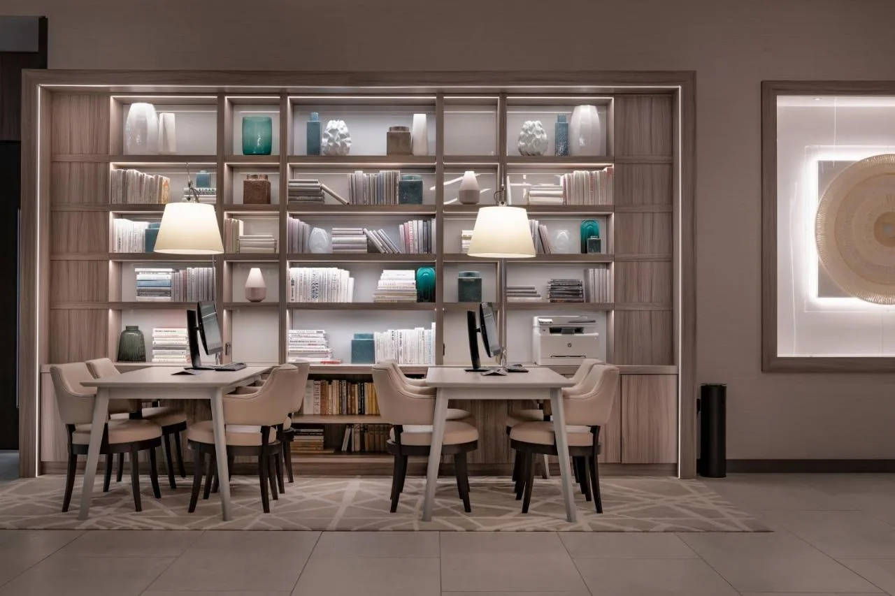 a dining room with two tables and chairs with computers on them at AC Hotel by Marriott Manchester City Centre in Manchester