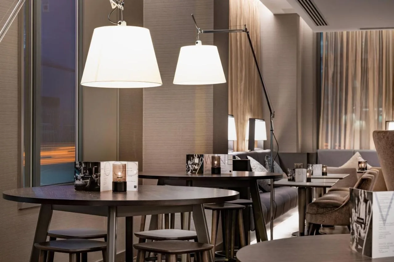 a restaurant with tables and chairs and lights at AC Hotel by Marriott Manchester City Centre in Manchester