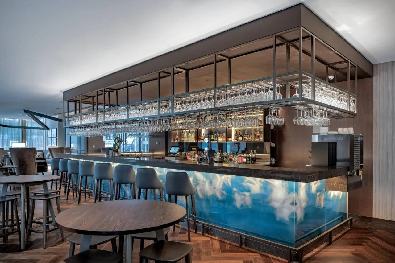 a bar with chairs and tables in a restaurant at AC Hotel by Marriott Manchester City Centre in Manchester
